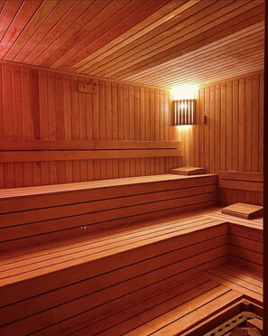 Un sauna de fusta amb bancs i un llum.