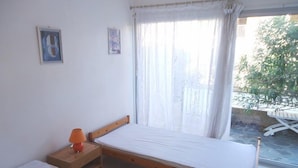 A bedroom with a single bed, a nightstand, a lamp, and a window with curtains. - BEAUTIFUL 2 BEDROOM APARTMENT WITH TERRACE 50 M BEACH WIFI (CAVALAIRE sur mer)