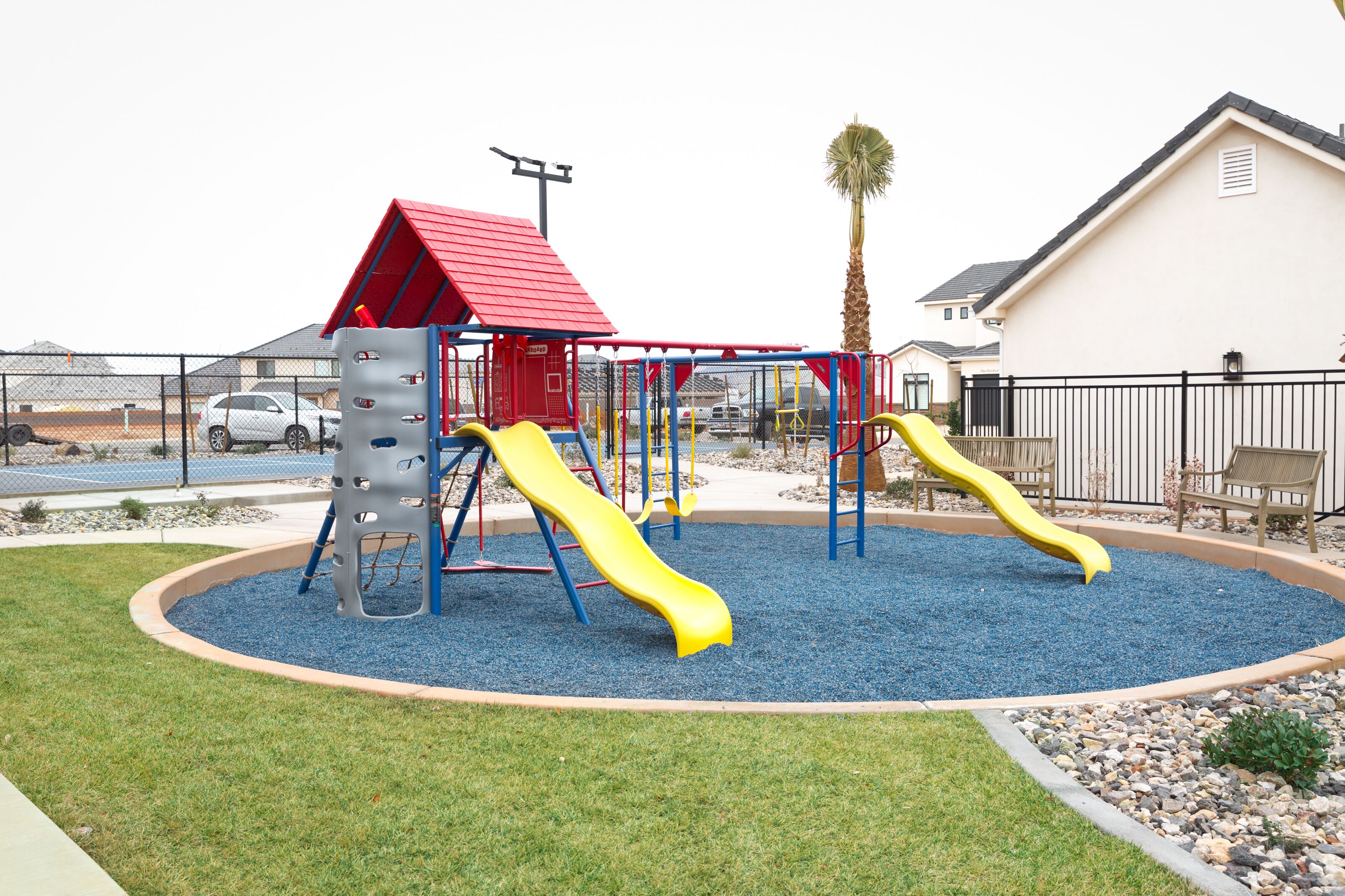 A playground with two slides and a red-roofed structure.