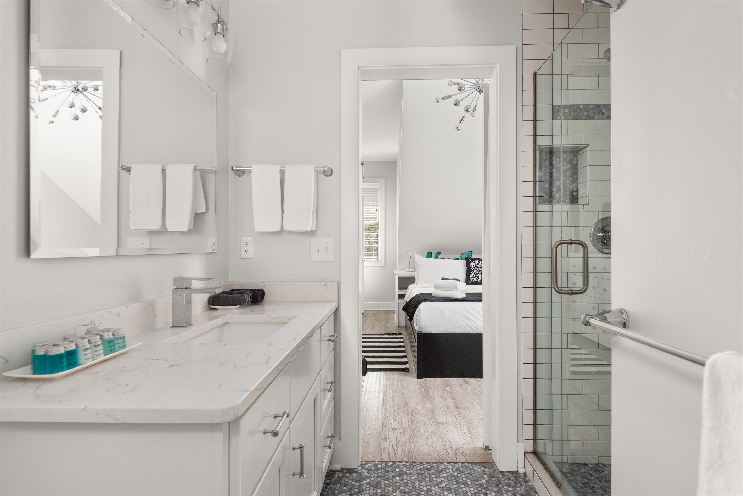 Un baño moderno con un espejo grande, dos lavamanos y una zona de ducha.