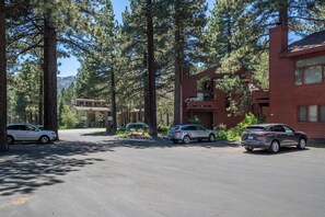 A residential area with multiple houses, a parking lot, and tall pine trees. - Townhouse Art Gallery in Mammoth's Best Location (Mammoth Lakes)