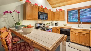 Une cuisine avec des meubles en bois, un four à micro-ondes, une cuisinière et un évier.