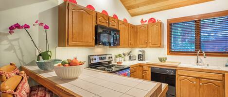 A kitchen with wooden cabinets, a microwave, a stove, and a sink.