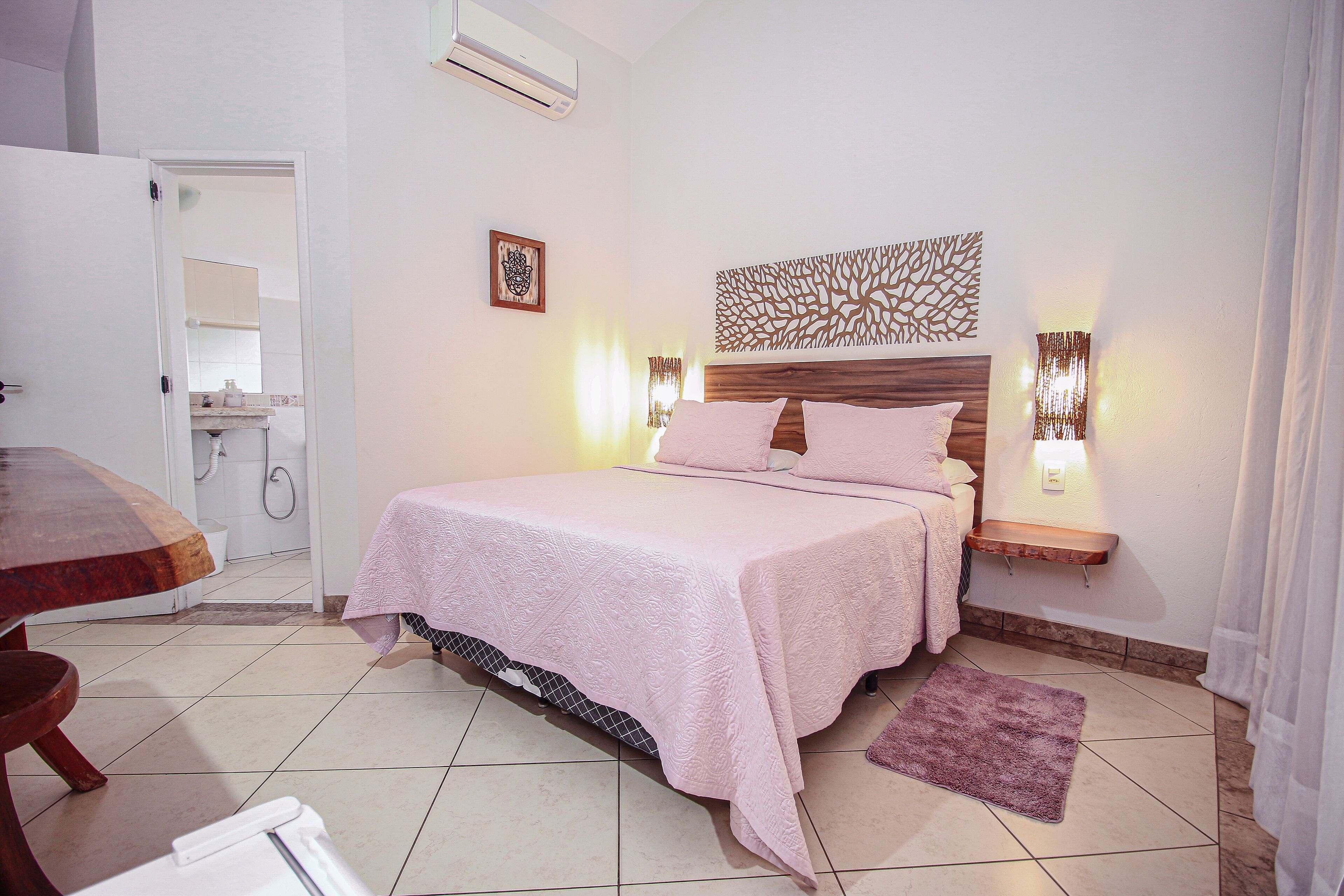 Un dormitorio con cama, mesitas de noche, un espejo y zona de ducha.