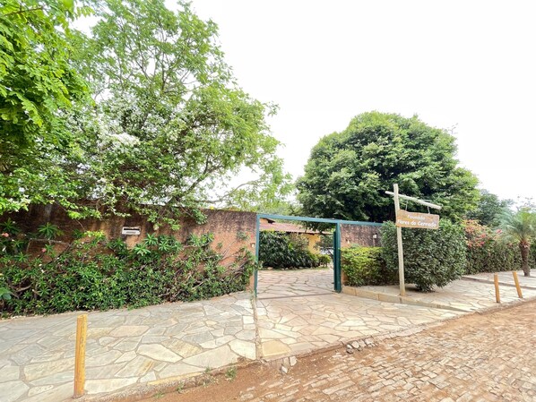 Una entrada pavimentada con un letrero que dice 'Flores do Cerrado'.