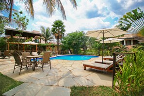 Una piscina al aire libre, sillones reclinables de piscina