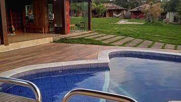 Alberca al aire libre y camastros