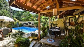 Una piscina al aire libre, sillones reclinables de piscina