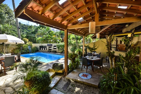 Una piscina al aire libre, sillones reclinables de piscina