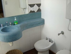 A bathroom with a blue sink, a white pedestal sink, and a bidet. - Apartamento Bella Vista (Salta)