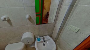Un baño pequeño con inodoro, lavabo y espejo.