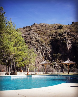 Een seizoensgebonden buitenzwembad en parasols bij het zwembad