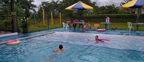 Piscina a l'aire lliure, para-sols i gandules