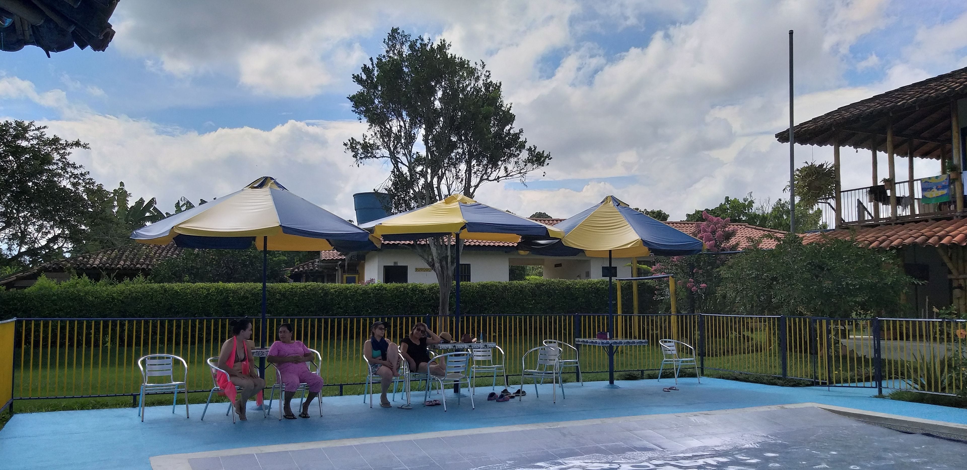 Una piscina al aire libre, sombrillas, tumbonas