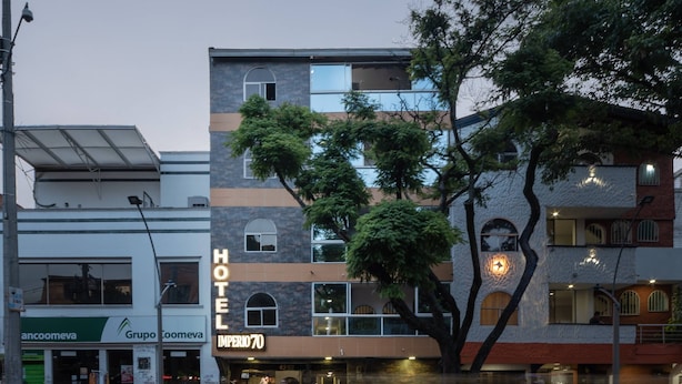 A hotel with a prominent 'HOTEL' sign, a visible entrance, and a street view with pedestrians and vehicles. - Ayenda 1234 Imperio 70 (Medellín)