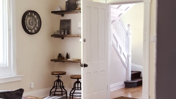 A room with a ceiling fan, a clock on the wall, a dining area with a table and chairs, and a staircase leading to another level. - The Eureka: Four King Bedroom House (Champaign)