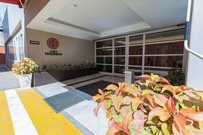 A hotel entrance with a sign reading "CHIFA PRESIDENTE," a large glass door, and potted plants. - Hotel Presidente Huancayo Asociado Casa Andina (Huancayo)