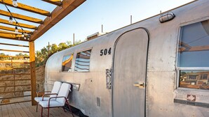 Un wagon de train d’époque, portant le numéro 504, avec un plancher en bois et une chaise blanche.