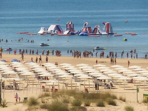 Una playa con muchos sombrillas y gente.