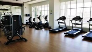 Un gimnasio con cintas de correr, bicicletas estáticas y máquinas de pesas.