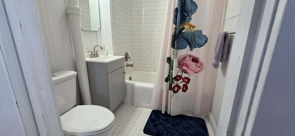 A bathroom with a toilet, sink, and bathtub.