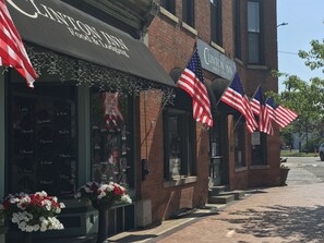 A brick building with a sign for Clinton Inn, featuring American flags and a window with names. - The Clinton Inn (Clinton)