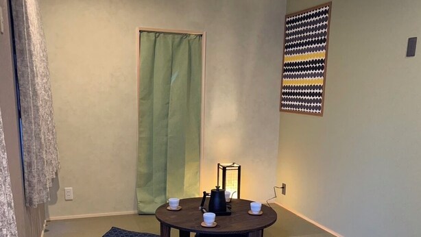 A room with tatami mats, a low table with cups and a kettle, and a wall-mounted decorative panel. - HOTEL PRELE SHINKAN (Tokyo)