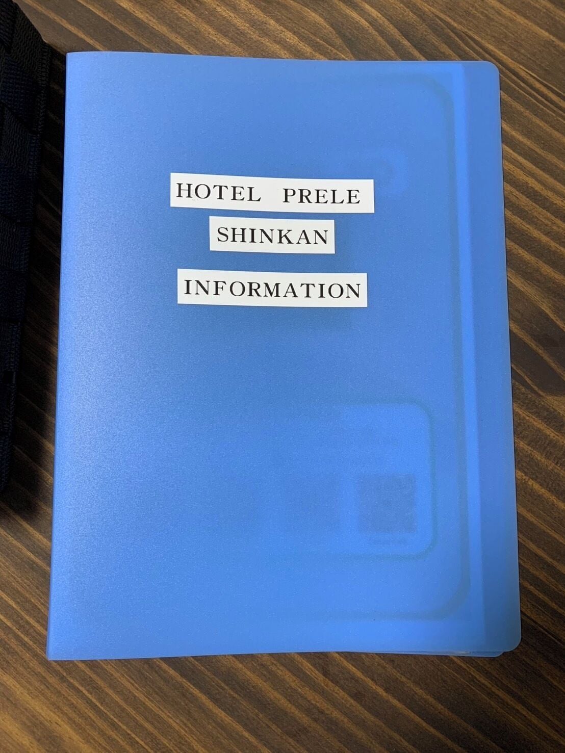 Una carpeta azul con el texto 'HOTEL PRELE SHINKAN INFORMATION'.
