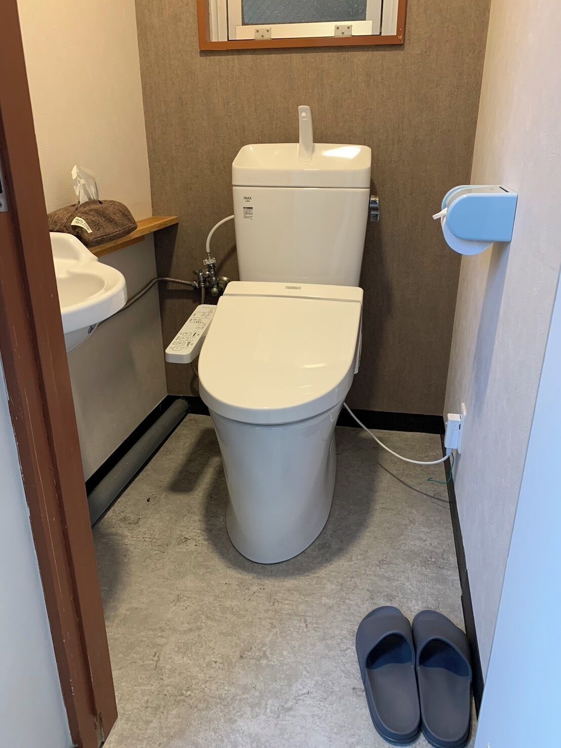 A small bathroom with a toilet, sink, and a window.