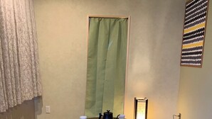A tatami mat room with a round table, four cushions, a tea set, and a green curtain. - HOTEL PRELE SHINKAN (Tokyo)