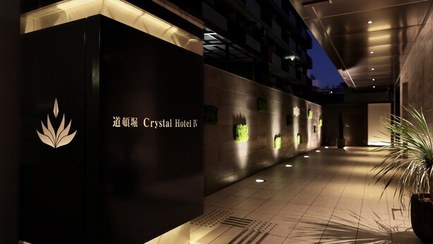 A hallway with a sign for Crystal Hotel IV, featuring a logo and text. - Doutonbori Crystal Hotel IV (Osaka)