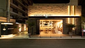 The exterior of the Crystal Hotel with a modern design, featuring a brick facade and illuminated signage. - Doutonbori Crystal Hotel IV (Osaka)