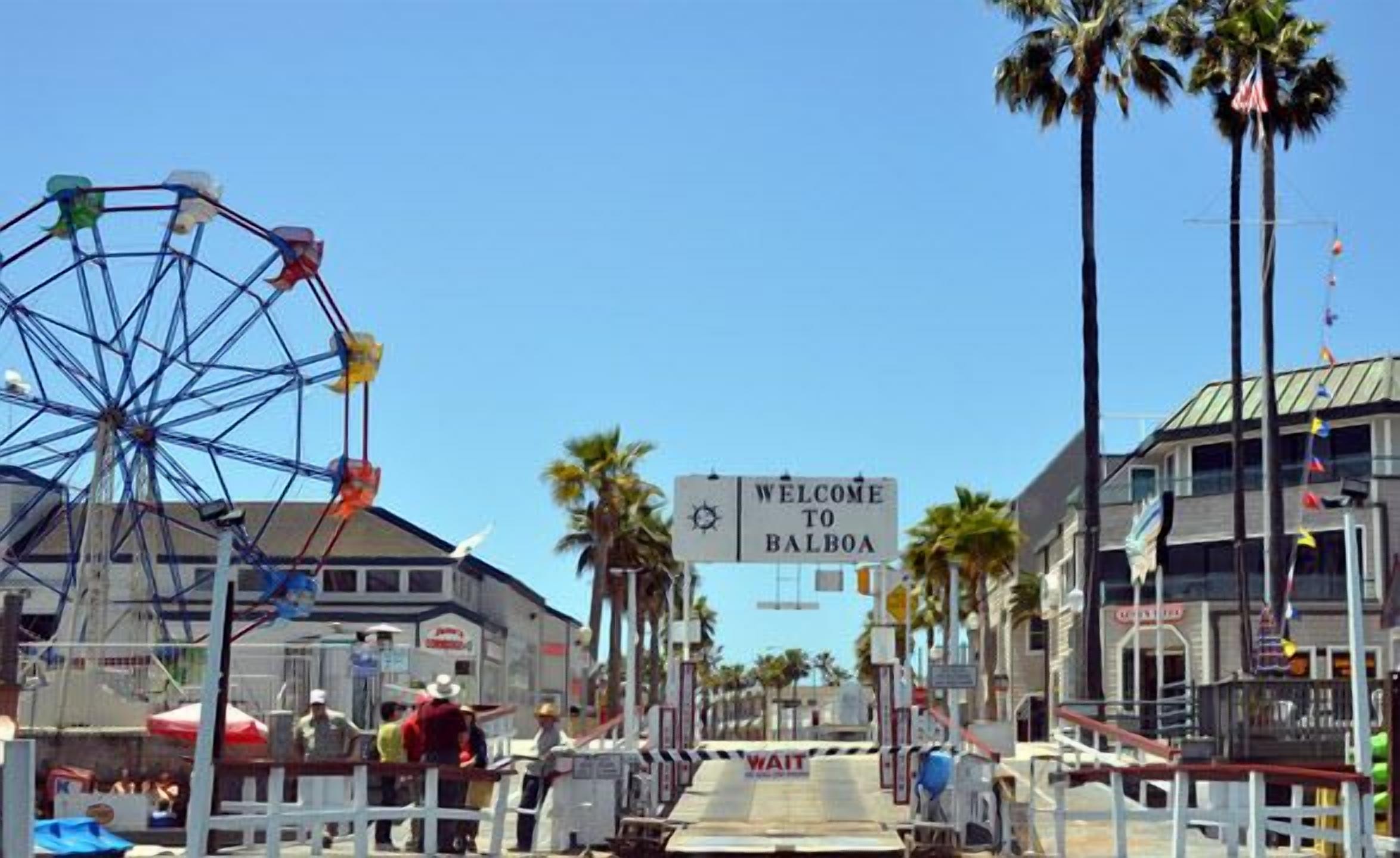 A Ferris wheel, palm trees, and a 'Welcome to Balboa' sign.