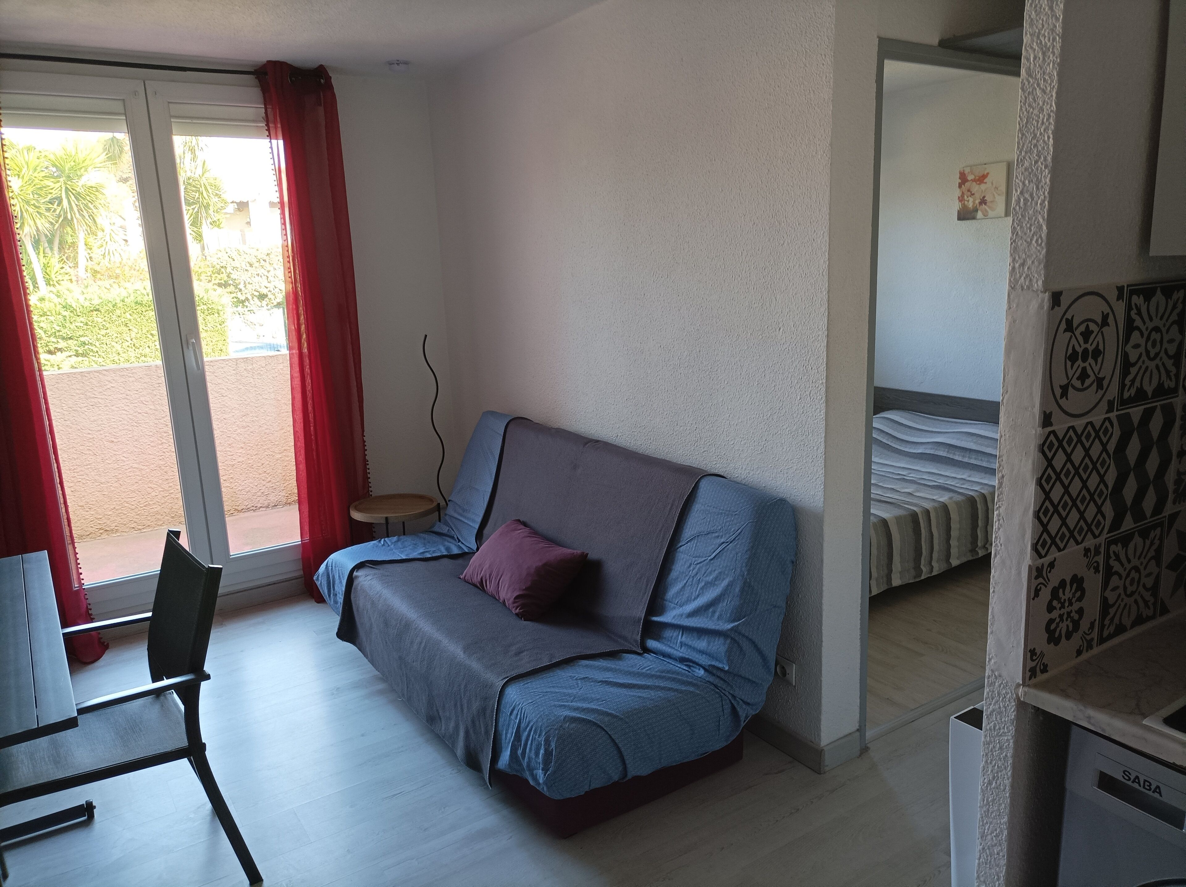 A small, modern room with a sofa, a small table, and a bed.