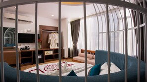A hotel room with a bed, a desk, a wardrobe, and a TV.
