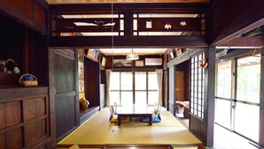 A traditional Japanese room with tatami flooring, a low table, and wooden furniture. - #Nerome01 Traditional Okinawan House in YAMBARU, eg  (Ogimi)
