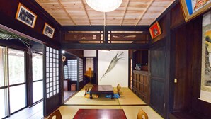 A traditional Japanese room with tatami flooring, a low wooden table, and shoji screens. - #Nerome01 Traditional Okinawan House in YAMBARU, eg  (Ogimi)