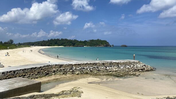 A beach with a stone wall, clear turquoise water, and a forested island in the distance. - #Nerome01 Traditional Okinawan House in YAMBARU, eg  (Ogimi)