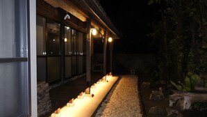 A building with a covered outdoor area, stone steps leading to a door, and a gravel path. - #Nerome01 Traditional Okinawan House in YAMBARU, eg  (Ogimi)