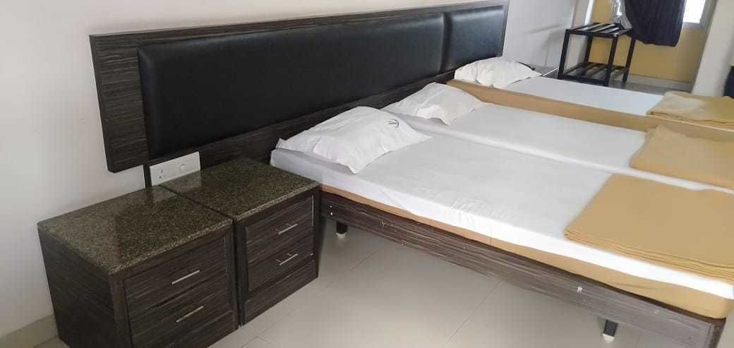 A bedroom with a bed, a nightstand, and a dresser.
