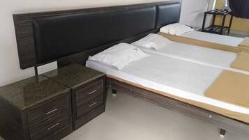 A bedroom with a bed, a nightstand, and a dresser.