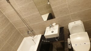 A bathroom with a bathtub, a sink, and a toilet.