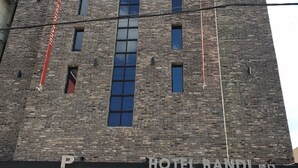 A tall brick building with the sign "HOTEL BANDI" at the top.