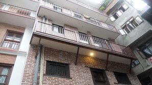 A multi-story building with brick walls, balconies, and windows. - Heritage De Patan (Lalitpur)