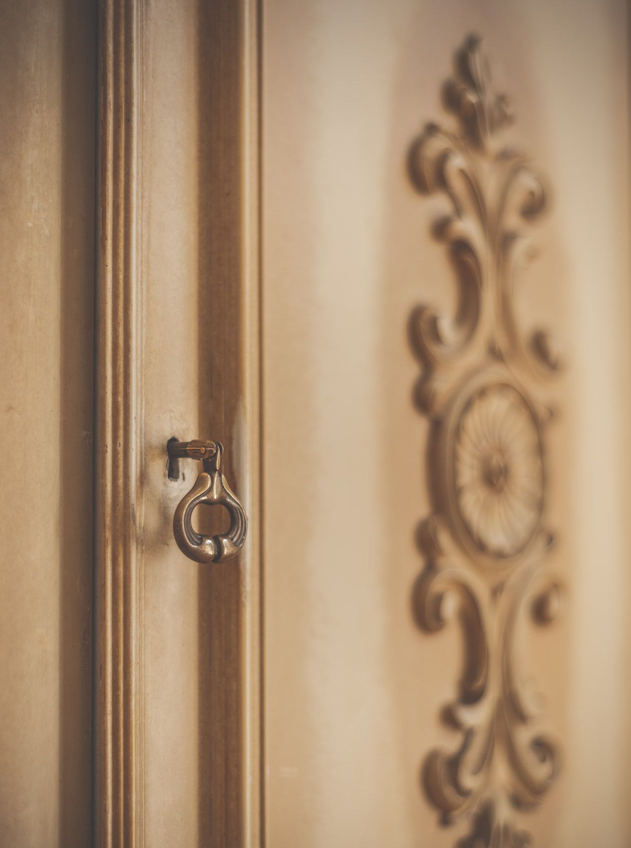 Una puerta con manija de latón y un diseño decorativo en el marco.