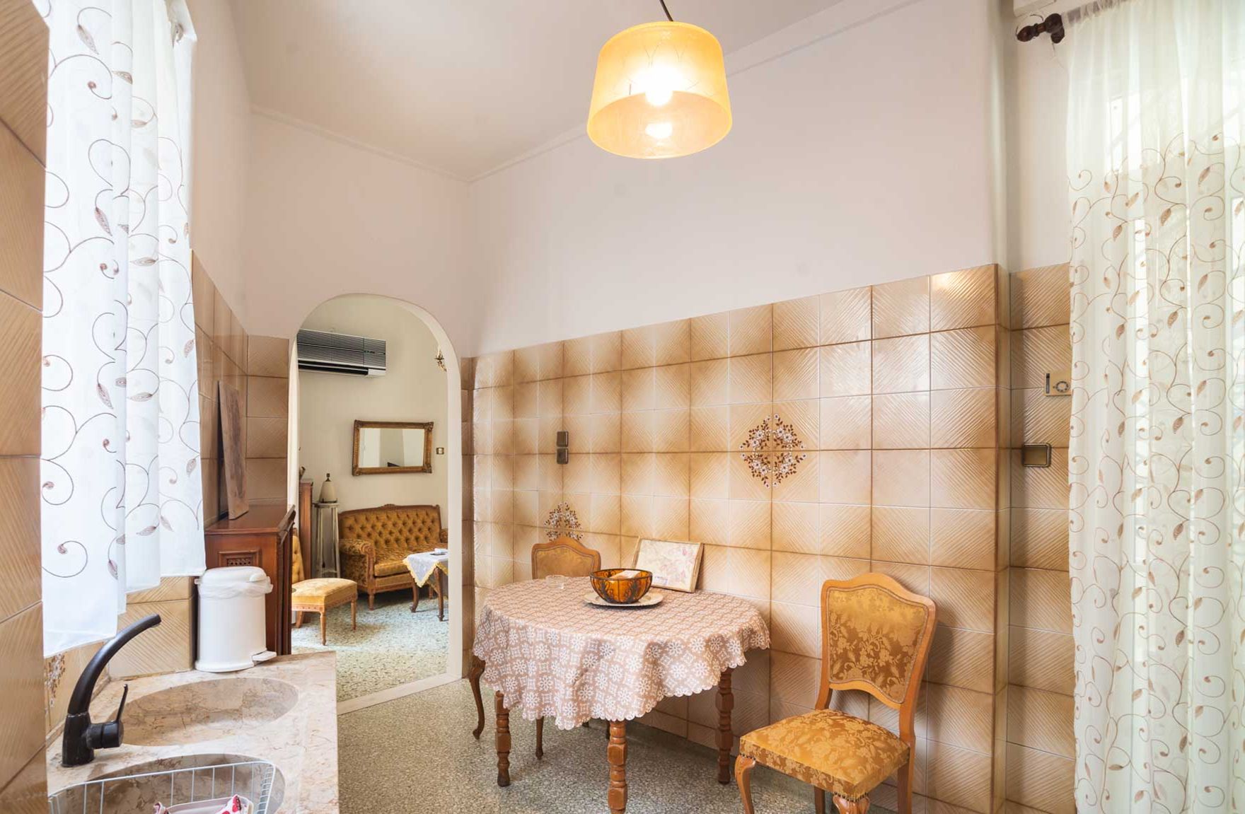 Un coin repas comprenant une table ronde, deux chaises, un mur décoratif et un luminaire suspendu.