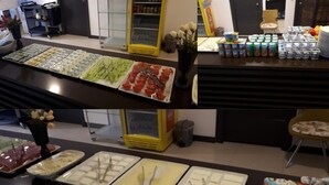 Een buffet met diverse gerechten, waaronder vleeswaren, kazen en fruit.