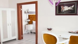 Une pièce avec une armoire blanche, un petit bureau blanc et une chaise jaune.