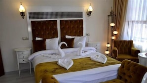 Une chambre d’hôtel avec un grand lit, deux tables de chevet, une chaise et une lampe sur pied.