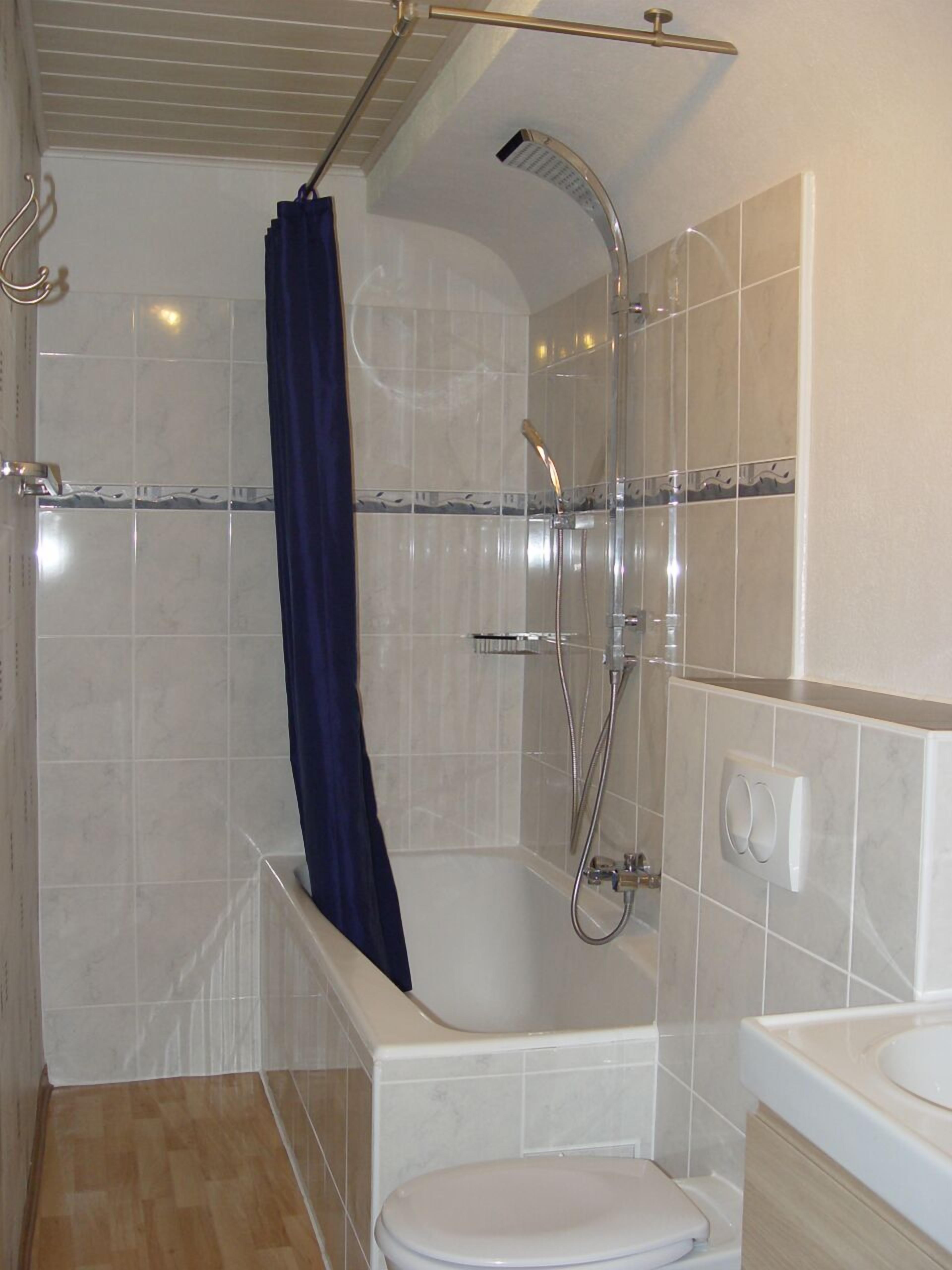 Ein Badezimmer mit Dusche, Toilette und Waschbecken.